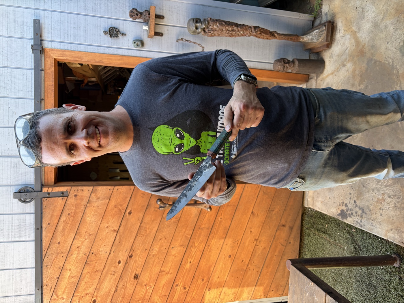 Reid, owner of Carlsbad Sharpening, holding a knife